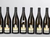 six bouteilles de vin sont alignées sur une table
