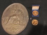 une médaille d'or et une médaille d'argent posées sur une table noire
