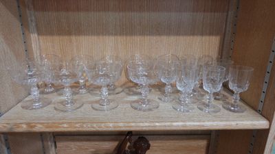 a wooden shelf with a bunch of wine glasses on it