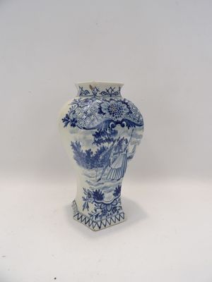 un vase bleu et blanc posé sur une surface blanche