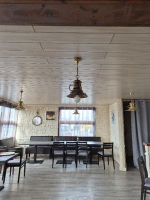 une salle à manger avec une table, des chaises et une horloge accrochée au mur