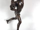 an antique bronze statue of a boy holding a bird on a wooden base