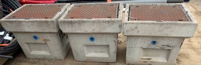 three cement containers are stacked on top of each other on the ground