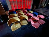 brightly colored chairs are lined up in a row in a dark room
