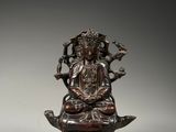 a bronze statue of a woman sitting on top of a lotus