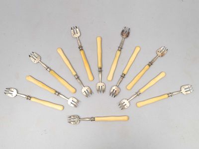 Plusieurs fourchettes et cuillères sont disposées en cercle sur une table