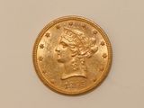 a close up of a gold coin on a white surface
