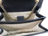 the inside of a black purse with a gold chain hanging from it