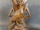 a bronze statue of a bird and a flower on a pedestal