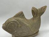statue d'un poisson en pierre sur fond blanc