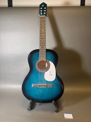 une guitare posée sur un support dans une pièce