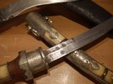 two knives that are laying on top of a wooden table