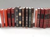 several books are lined up in a row on a white surface