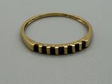 un gros plan d'une bague en or sertie de pierres noires