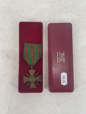 medal in a red case sitting on a white surface next to a red box
