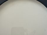 a white plate with a black rim on a wooden table