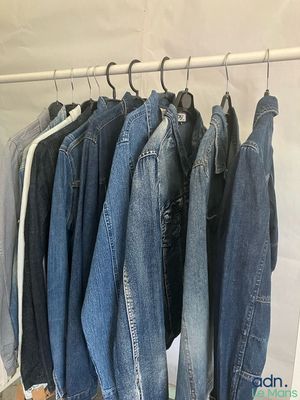 plusieurs paires de jeans suspendues à un portant dans un placard