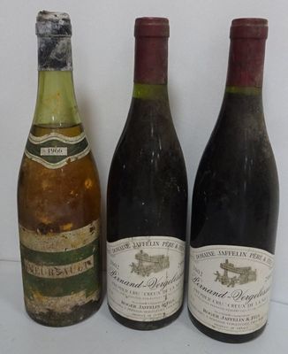 three bottles of wine are lined up on a white surface
