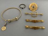 several gold jewelry items including a ring, bracelet, and a coin