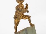 bronze statue of a man holding a bird on a marble block