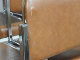 several brown leather chairs are lined up in a row in a room