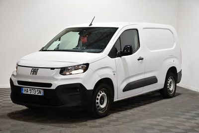 la camionnette blanche est garée dans une pièce au sol en damier