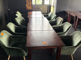 de nombreuses chaises vertes disposées autour d'une longue table dans une pièce