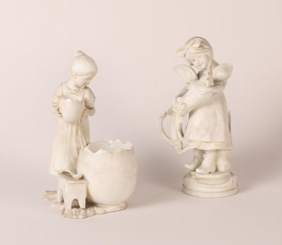 une paire de statues blanches représentant des enfants arrosant une jardinière