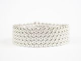 gros plan d'un bracelet en argent sur fond blanc
