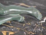 a statue of a person laying down on a marble table