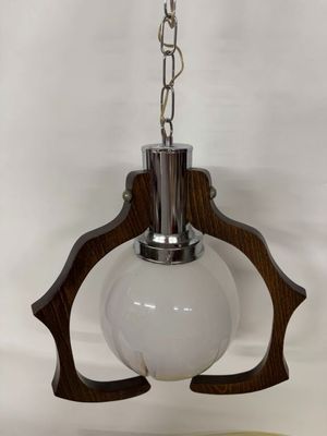 a close up of a lamp hanging from a chain on a wall