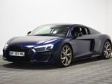 une voiture de sport Audi bleue garée dans une pièce au sol à carreaux