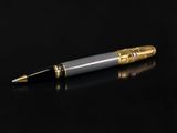 a silver and gold pen sitting on top of a black surface