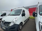 several white vans parked in a parking lot next to a red building