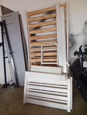 a white bed frame with a wooden slatt on it