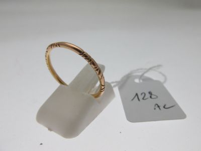 une image représentant une bague en or avec une étiquette de prix, posée sur une surface blanche