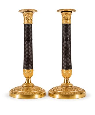 une paire de bougeoirs dorés et noirs sur fond blanc