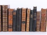 plusieurs vieux livres sont alignés sur une surface blanche