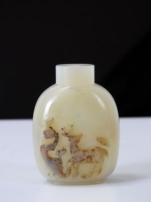 une bouteille en verre blanche sur laquelle est représenté un cheval