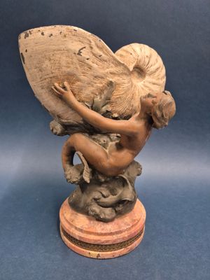 statue d'une femme tenant un éventail, posée sur un socle en bois