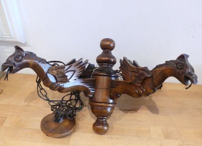 une statue de dragon posée sur une table, avec une paire de chaussures à côté