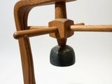a small wooden object with a bell on it