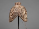 a close up of a wooden fish head on a metal stand