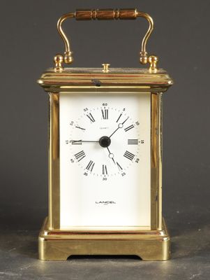 an antique brass carriage clock with roman numerals on the face