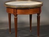 une table ronde avec un plateau en marbre et des pieds en bois