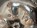 a silver object with a bird on it