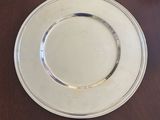 a white plate with a silver rim on a wooden table