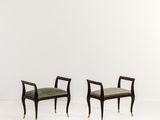 une paire de chaises noires et dorées avec des coussins rembourrés verts