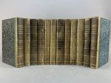six vieux livres sont alignés sur une surface blanche