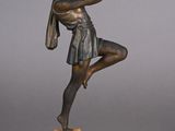 statue en bronze représentant une femme tenant une raquette de tennis, posée sur un socle en marbre